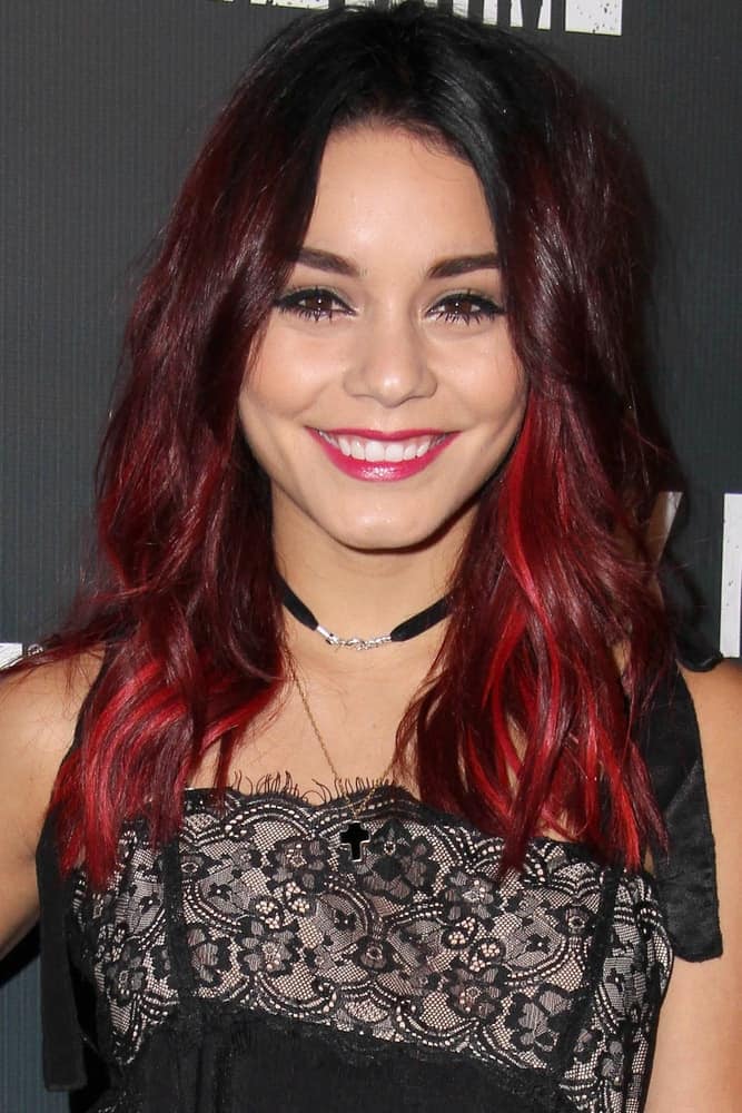 Vanessa Hudgens was at the Knott's Scary Farm Celebrity VIP Opening at Knott's Berry Farm on October 3, 2014 in Buena Park, CA. She came wearing a black embroidered outfit that went quite well with her wavy and loose tousled shoulder-length hairstyle with red highlights.