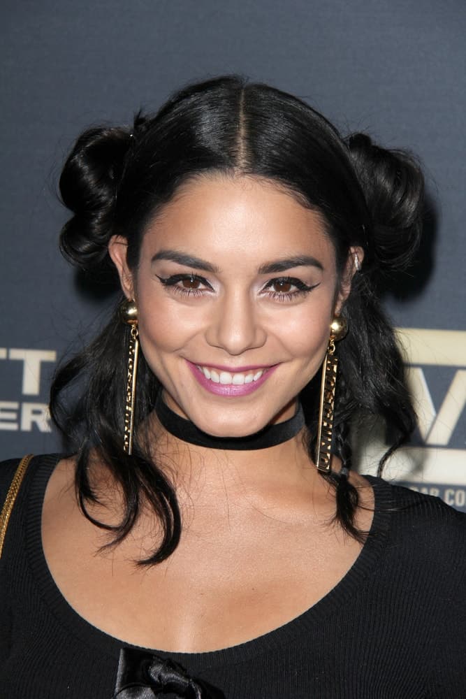 Vanessa Hudgens wore a simple black outfit to go with her charming and messy double bun hairstyle with loose tendrils on both sides at the "Jeremy Scott: The People's Designer" World Premiere at the TCL Chinese Theater on September 8, 2015 in Los Angeles, CA.