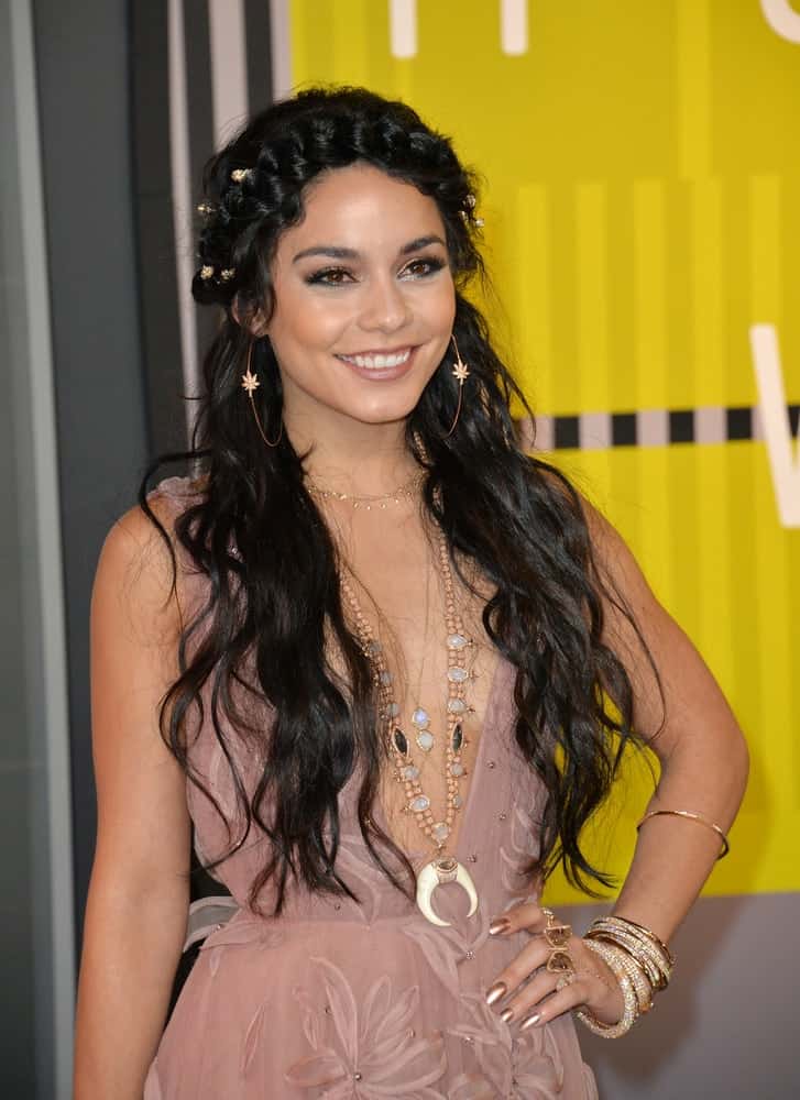 On August 30, 2015, Vanessa Hudgens was at the 2015 MTV Video Music Awards at the Microsoft Theatre LA Live. She was charming in her sheer floral dress and long wavy raven hairstyle incorporated with a crown braid.