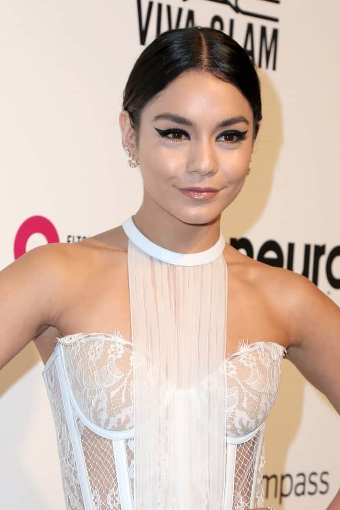 Vanessa Hudgens wore a stunning embroidered white outfit with her slick center-parted hairstyle and cat-eye make-up at the 25th Annual Elton John Academy Awards Viewing Party at the City of West Hollywood Park on February 26, 2017 in West Hollywood, CA.
