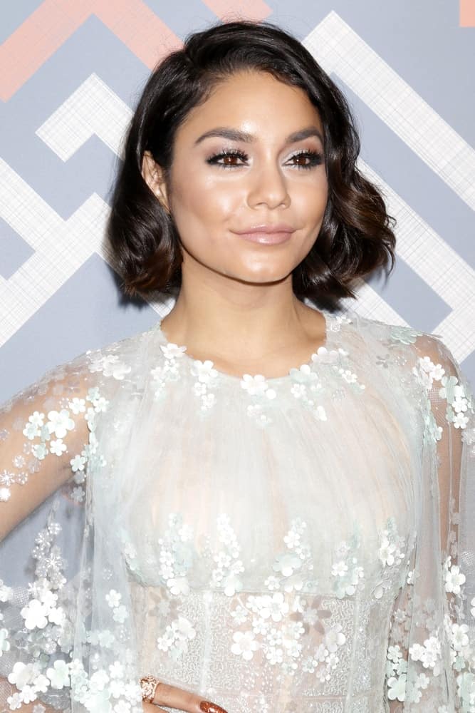 Vanessa Hudgens attended the FOX TCA Summer 2017 Party at the Soho House on August 8, 2017 in West Hollywood, CA. Her fashionable white floral dress paired quite well with her short and tousled raven hair with subtle highlights and curls at the tips.
