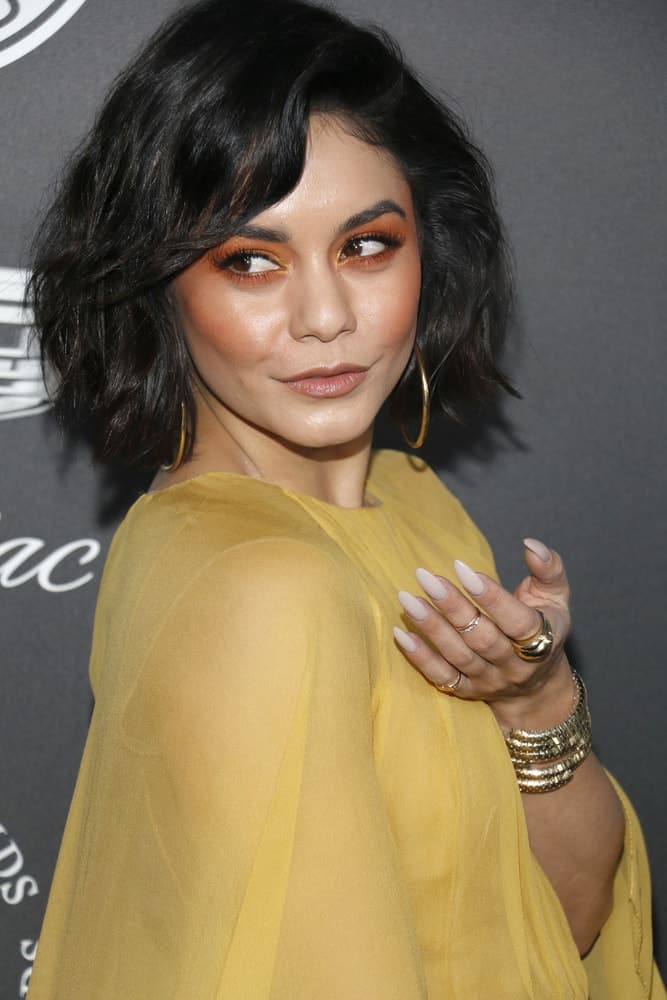 Vanessa Hudgens' charming yellow sheer dress went quite well with her tousled short bob hairstyle with side-swept bangs at the Art Of Elysium's 11th Annual Heaven Celebration held at the Barker Hangar in Santa Monica, USA on January 6, 2018.