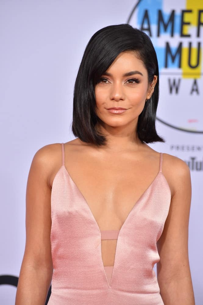 On October 09, 2018, Vanessa Hudgens wore a charming pink dress that she paired with her straight, layered and loose raven bob hairstyle that has flippy tips at the 2018 American Music Awards at the Microsoft Theatre LA Live in Los Angeles, CA.