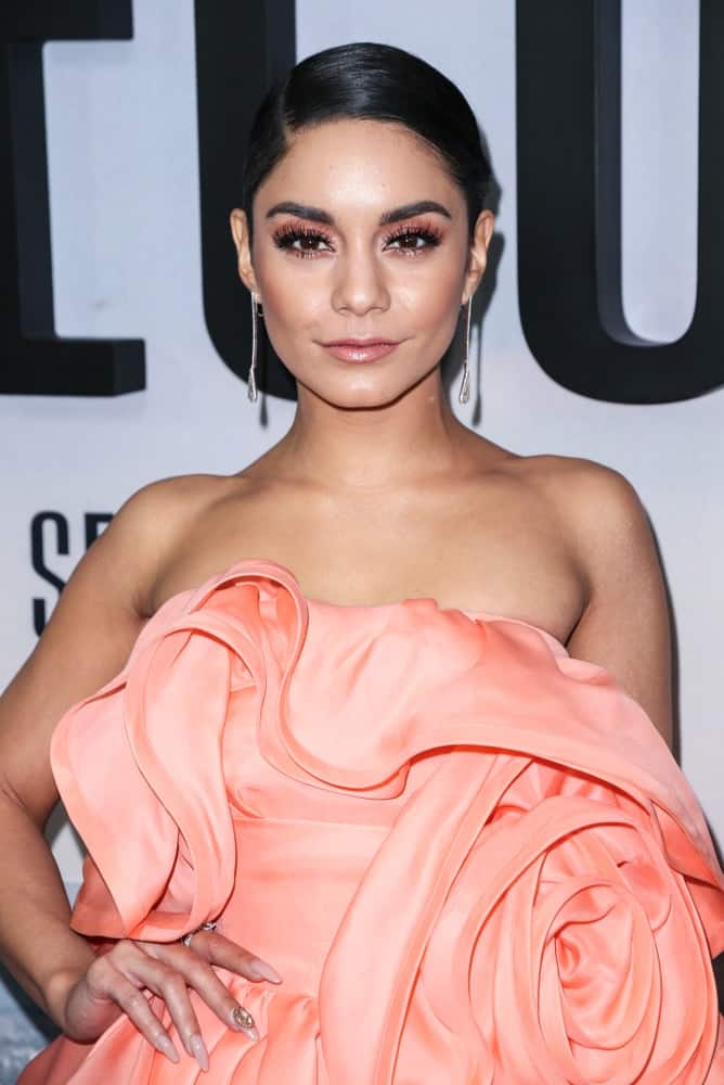 On December 12, 2018, Vanessa Hudgens wore a beautiful pink dress by Marc Jacobs with her slick, side-parted and neat raven hairstyle at the world premiere of 'Second Act' at Regal Union Square Theatre.