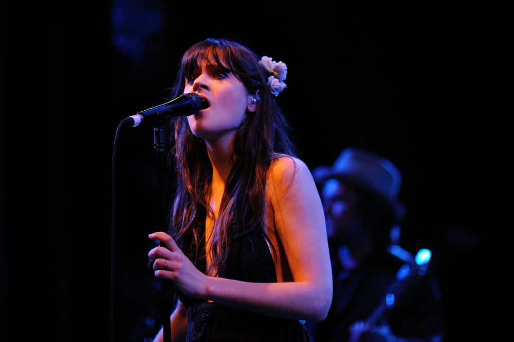Zooey Deschanel performed with her band She & Him at the Apollo on April 25, 2010 in Barcelona, Spain. She wore a black dress with her long and tousled dark brunette layers incorporated with a flower.
