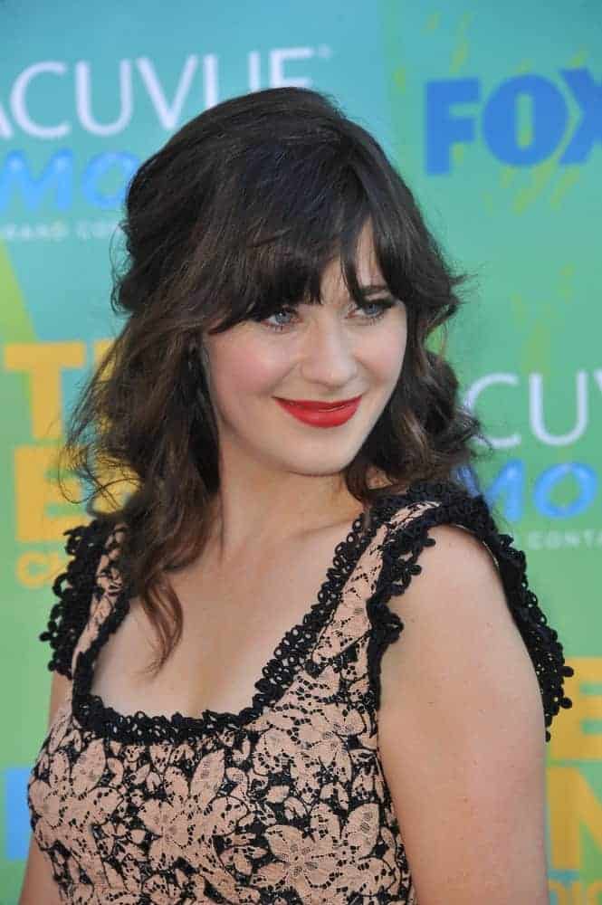 Zooey Deschanel was at the 2011 Teen Choice Awards at the Gibson Amphitheatre, Universal Studios, Hollywood on August 7, 2011, in Los Angeles, CA. She wore a floral dress to pair with her long and tousled wavy dark half-up hairstyle with bangs.