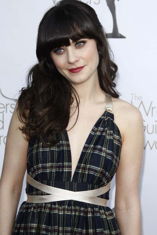 Zooey Deschanel attended the 2012 Writers Guild Awards at The Hollywood Palladium on February 19, 2012 in Los Angeles, California. She paired her lovely sundress with a side-swept curly brunette hairstyle that has blunt bangs.
