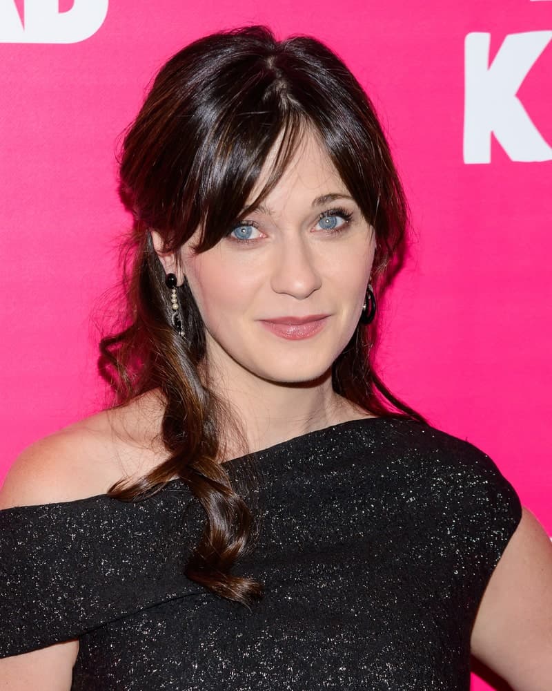 Zooey Deschanel attended the premiere of "Rock the Kasbah" in New York, New York on October 19, 2015. She paired her black dress with a long and dark half-up hairstyle with a slight tousle and long bangs.