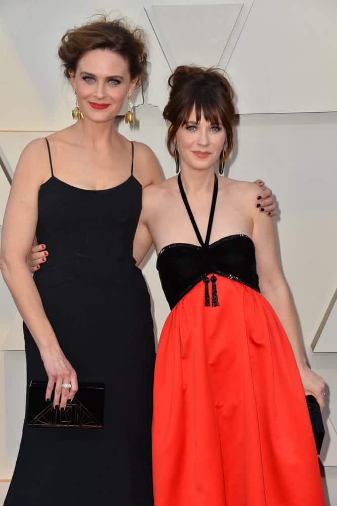On February 24, 2019, Zooey Deschanel & Emily Deschanel were at the 91st Academy Awards at the Dolby Theatre. Zooey wore a lovely dress with her messy dark brunette bun hairstyle with loose tendrils and bangs.