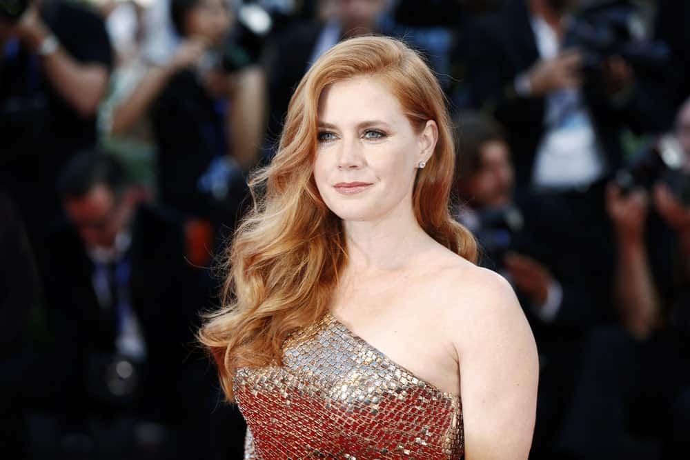 Amy Adams attended the premiere of 'Nocturnal Animals' during the 73rd Venice Film Festival on September 2, 2016, in Venice, Italy. She wore an elegant gown with her long and layered red hair side-swept with waves on her shoulder.