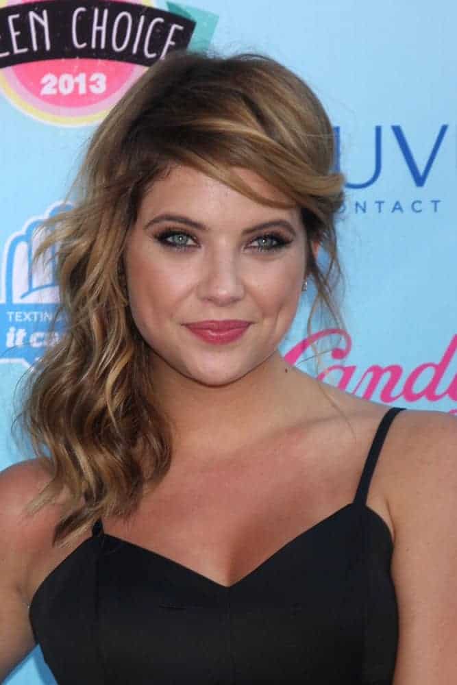 Ashley Benson was at the 2013 Teen Choice Awards at the Gibson Amphitheater Universal on August 11, 2013, in Los Angeles, CA. She wore a stunning black dress with her highlighted side-swept hairstyle with beach waves and a brown tone.