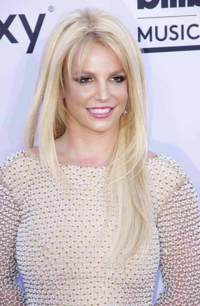 Britney Spears's simple layered straight loose hairstyle with choppy bangs creates a nice frame around her oval face at the 2015 Billboard Music Awards on May 17, 2015.