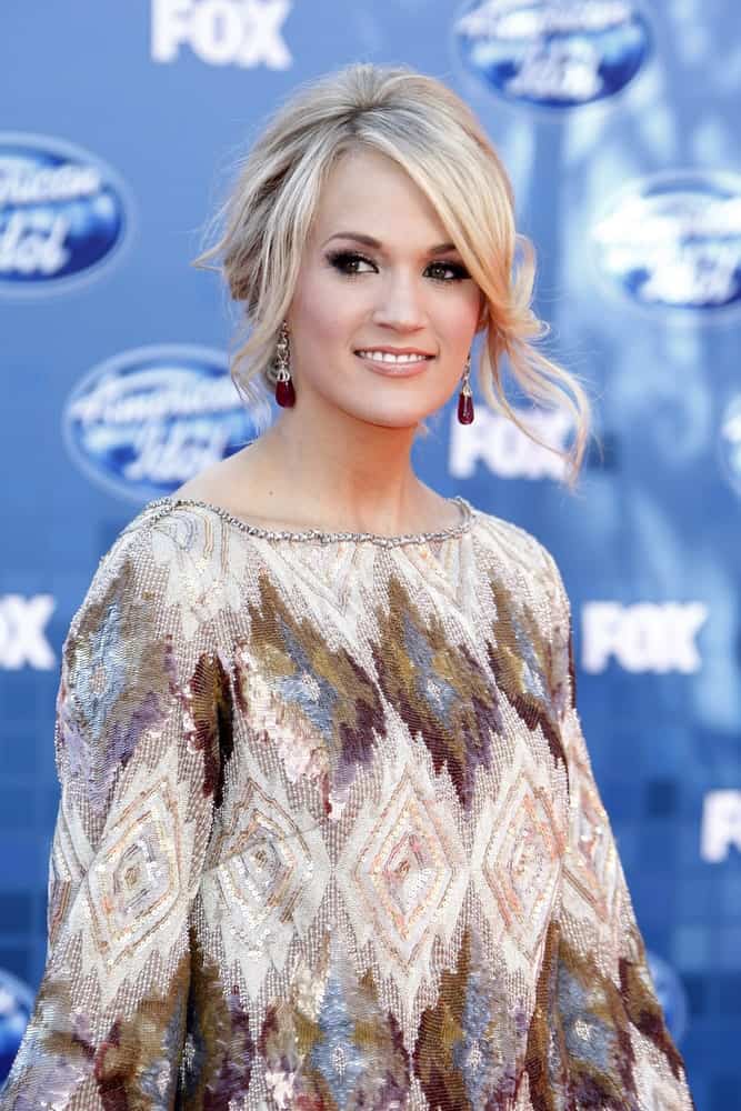 Carrie Underwood was seen at the American Idol Finale last May 25, 2011 sporting an updo hairstyle with loose tendrils and side bangs.