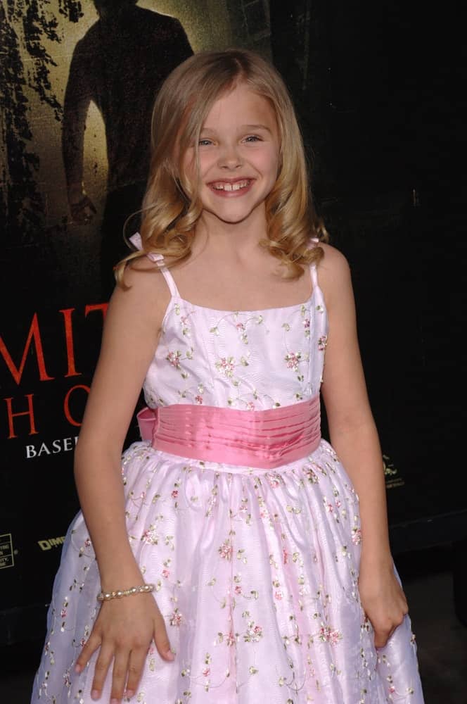Young actress Chloe Grace Moretz was at the world premiere of her new movie The Amityville Horror on April 7, 2005. She wore a white floral dress with her sandy blonde hairstyle that has curls at the tips.