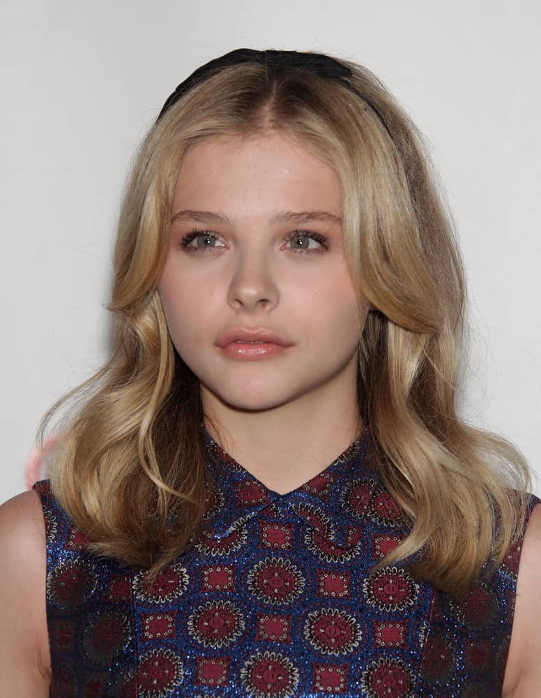Chloe Grace Moretz attended the Cinema Con 2012-Final Night Awards on April 26, 2012 in Las Vegas, NV. She wore a floral colorful dress and paired it with a loose and wavy layered sandy blonde hairstyle with long side bangs.