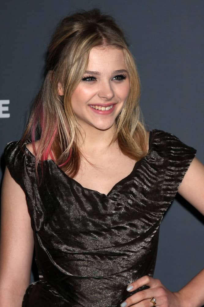 Chloe Grace Moretz was at the 14th Annual Costume Designers Guild Awards at the Beverly Hilton Hotel on February 21, 2012 in Beverly Hills, CA. She came wearing a black dress that she paired with a highlighted brunette half-up hairstyle with layers and a slight tousle.