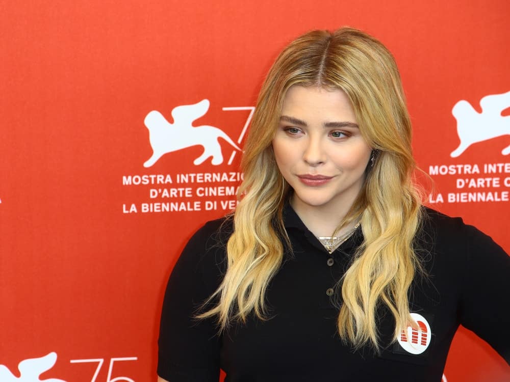 Chloe Grace Moretz attended the 'Suspiria' photocall during the 75th Venice Film Festival at Sala Casino on September 1, 2018 in Venice, Italy. She wore a black casual outfit to pair with her layered and highlighted sandy blonde hairstyle with waves.
