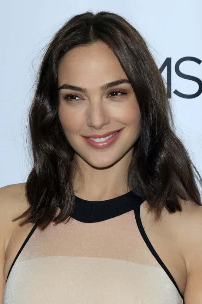 Gal Gadot was at The Moms Present a Screening of 'Keeping Up With the Joneses' at The London Hotel on October 20, 2016, in West Hollywood, CA. She came in a simple beige dress that she paired with simple makeup and shoulder-length loose tousled hair with subtle layers.