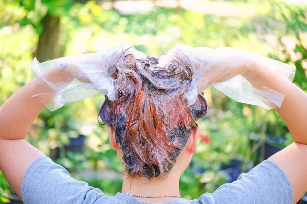 Frau färbt sich die Haare