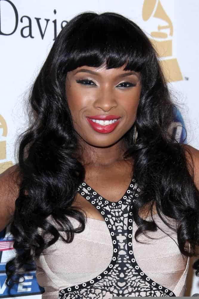 Jennifer Hudson was at the 2011 Pre-GRAMMY Gala And Salute To Industry Icons at Beverly Hilton Hotel on February 12, 2011 in Beverly Hills, CA. She paired her stunning dress with a long and tousled curly raven hairstyle with blunt bangs.