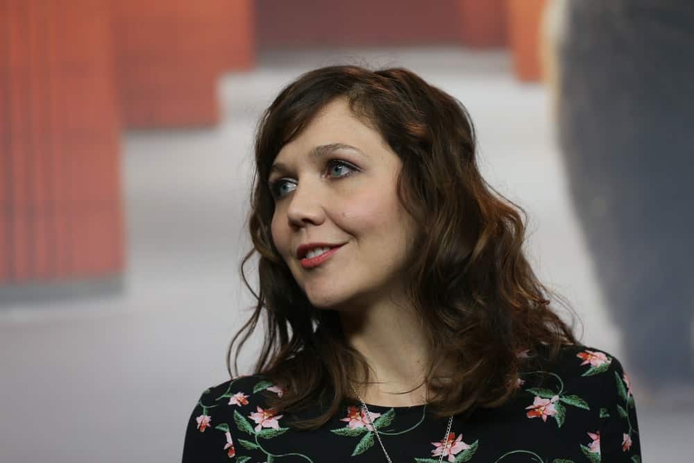Maggie Gyllenhaal attended the International Jury press conference during the 67th Berlinale International Film Festival Berlin at Grand Hyatt Hotel on February 9, 2017 in Berlin, Germany. She wore a black floral dress with her medium-length curly and highlighted hairstyle that is loose and tousled.