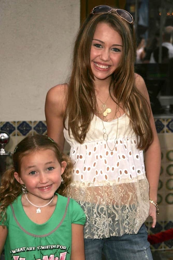 Miley Cyrus and sister were at the premiere of "Monster House" at Mann Village Theater July 17, 2006 in Westwood, CA. Miley decorated her long layered hairstyle with highlights and a pair of sunglasses.
