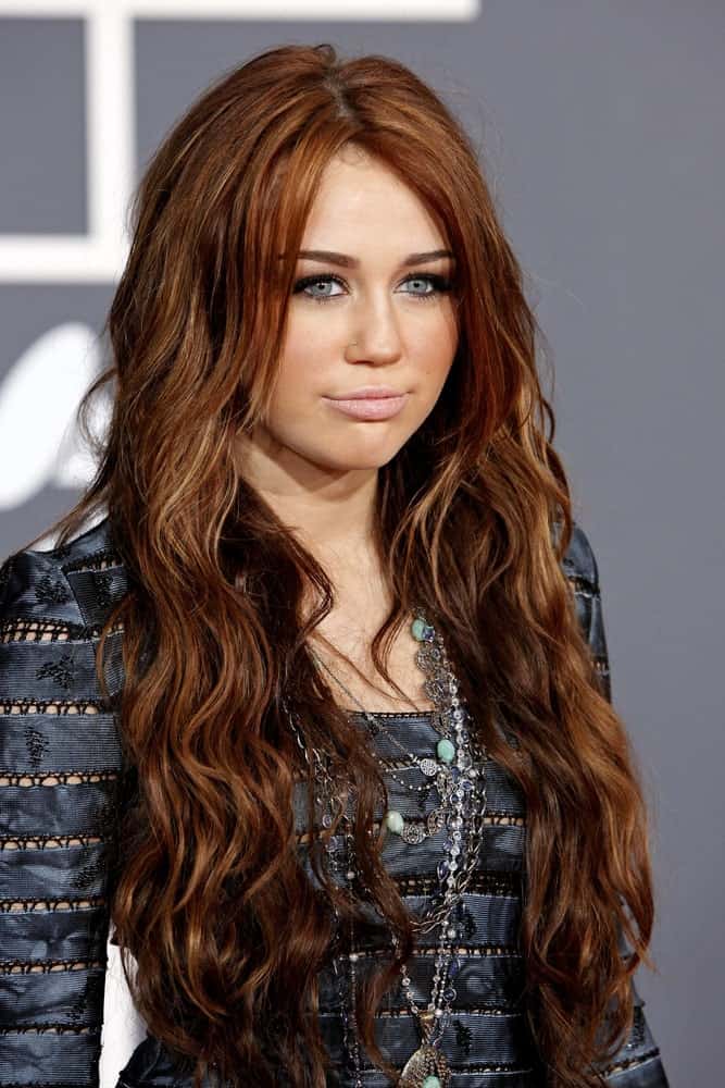 Miley Cyrus styled her reddish brown highlighted hair into a lovely long curly layered hairstyle when she arrived at the 52nd Annual GRAMMY Awards held at Staples Center in Los Angeles, California on January 31, 2010.