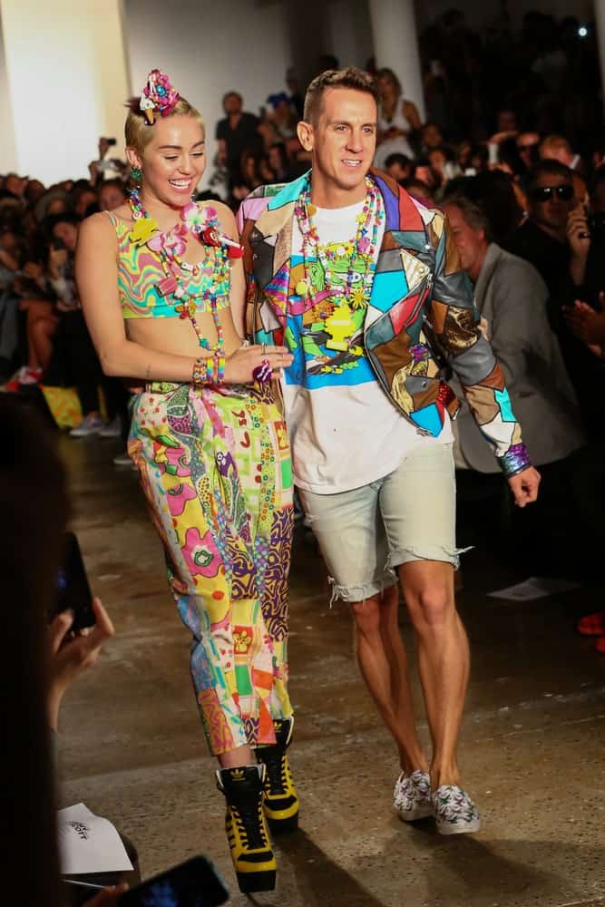 Miley Cyrus and designer Jeremy Scott walked the runway during MADE Fashion Week Spring 2015 at Milk Studios on September 10, 2014. Cyrus wore a colorful sexy outfit that went well with the headdress she wore on her side-swept pixie hairstyle.