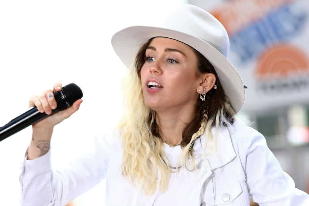 Miley Cyrus performed on the NBC "Today" show concert series on May 26, 2017 in New York City. She was lovely in her dyed loose and tousled hair incorporated with a tiny braid on the side topped with a white hat that matches her outfit.