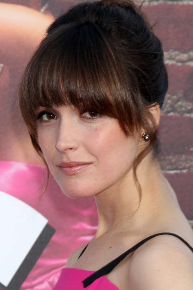 Rose Byrne was at the "Bridesmaids" Premiere at Village Theater on April 27, 2011 in Westwood, CA. She paired her pink dress with an upstyle bun hairstyle with blunt bangs and loose tendrils.