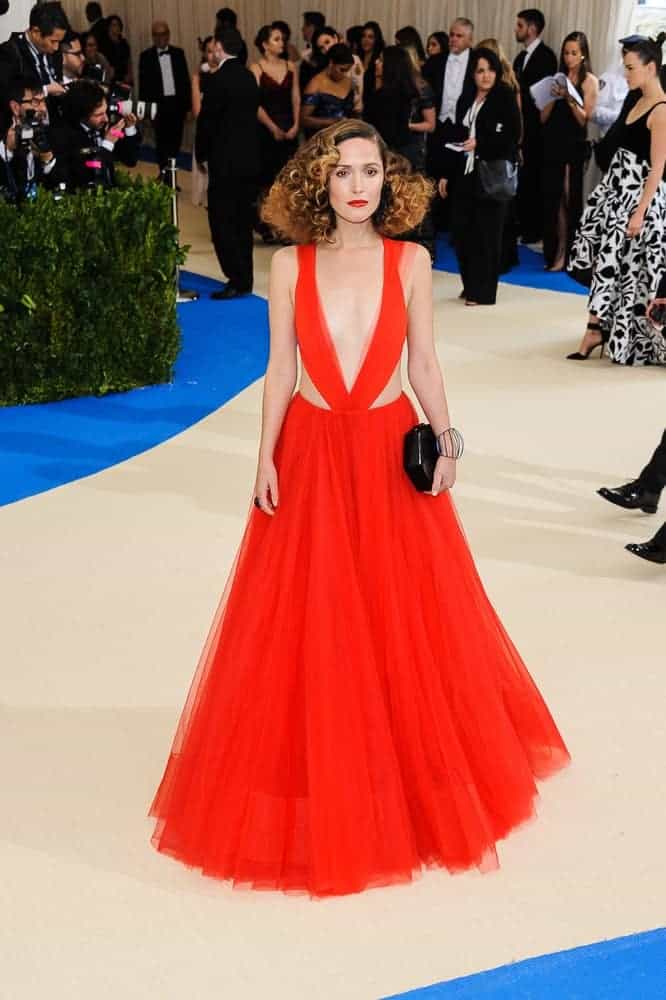 Rose Byrne attended the 2017 Metropolitan Museum of Art Costume Institute Gala at the Metropolitan Museum of Art in New York, NY on May 1, 2017. She was seen wearing a gorgeous orange gown paired with a shoulder-length curly hairstyle with highlights and layers.