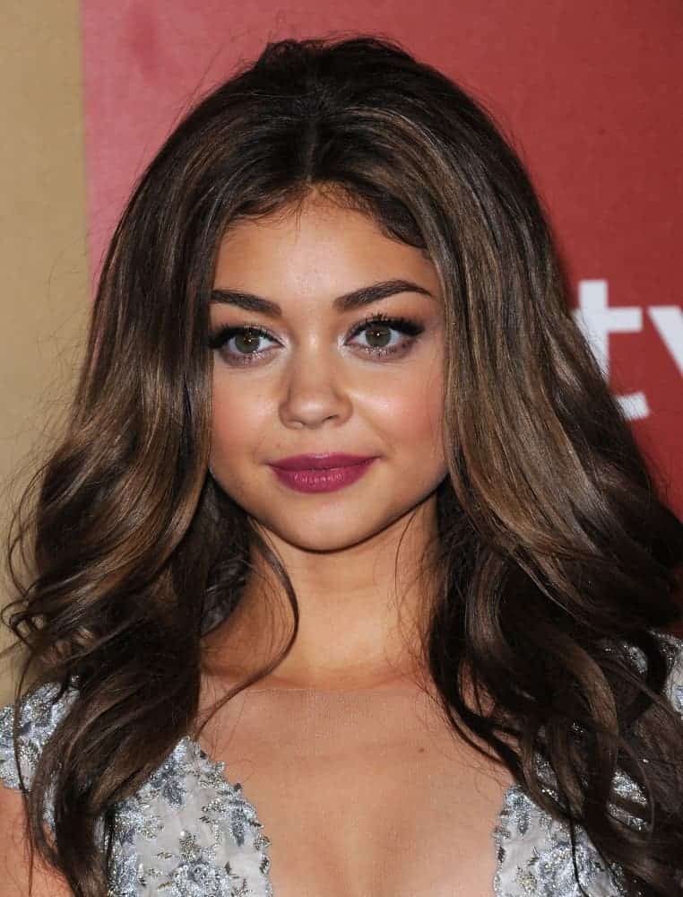 Sarah Hyland attended the WB/In Style Golden Globe Party on January 13, 2013, in Hollywood, CA. She wore a silver dress that she paired with her long and loose brunette hairstyle that has waves, layers, and a slight tousle.