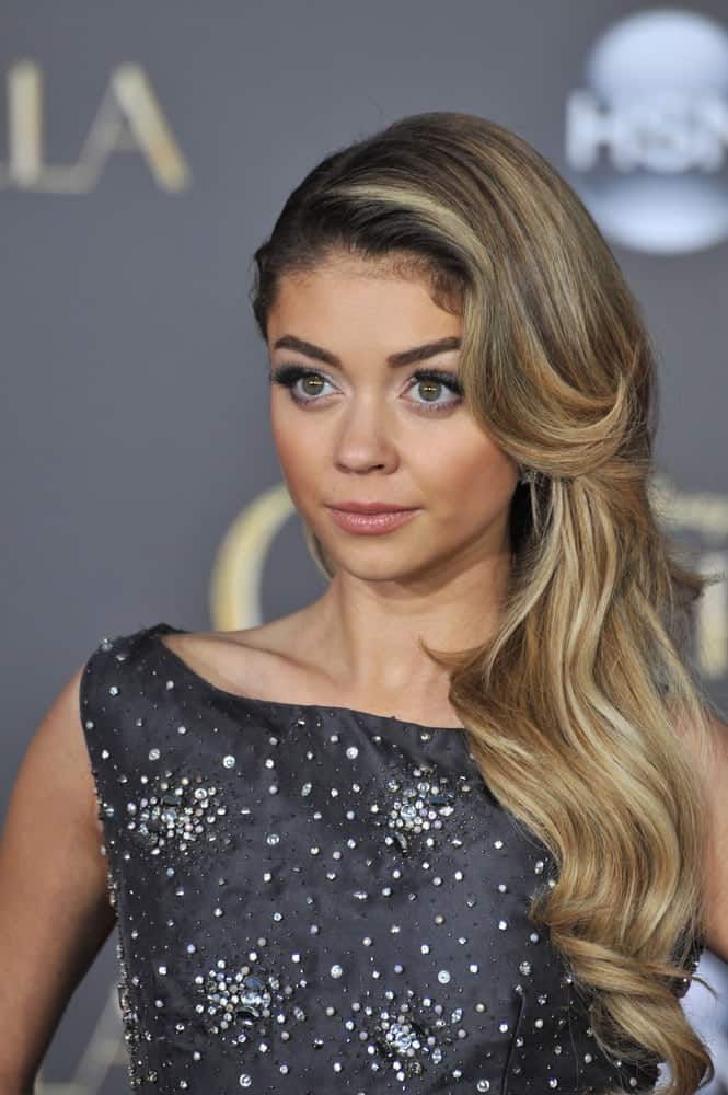 On March 1, 2015, Sarah Hyland at the world premiere of "Cinderella" at the El Capitan Theatre, Hollywood. She wore a bedazzled dress that she paired with her elegant side-swept hairstyle with layers, waves and a sandy blonde tone.
