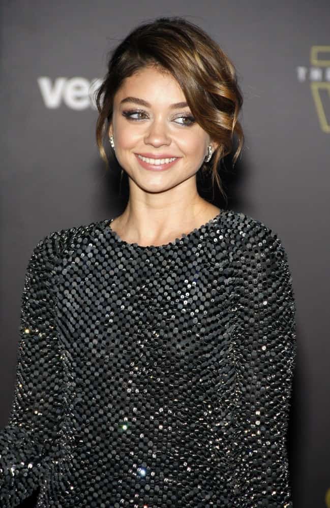 Sarah Hyland was at the World premiere of 'Star Wars: The Force Awakens' held at the TCL Chinese Theatre in Hollywood on December 14, 2015. She wore a black dazzling dress to pair with her brunette bun hairstyle that has loose side-swept bangs.