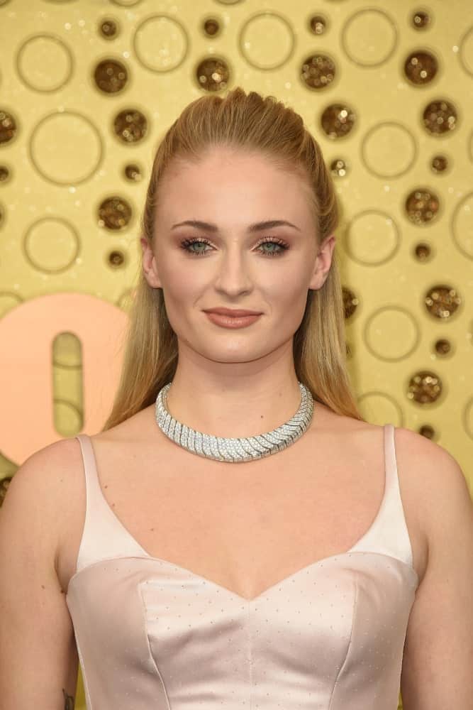 The English actress looking sleek in a half ponytail hairstyle complemented with a collar necklace and a blush bodice dress. This was taken at the Primetime Emmy Awards - Arrivals held on September 22, 2019.