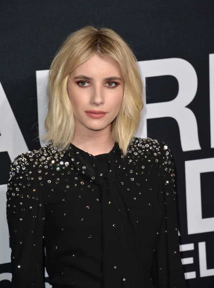 On February 10, 2016, actress Emma Roberts was at Saint Laurent at the Palladium fashion show at the Hollywood Palladium. She wore a sparkly black dress with her shoulder-length tousled blonde bob hairstyle with layers.