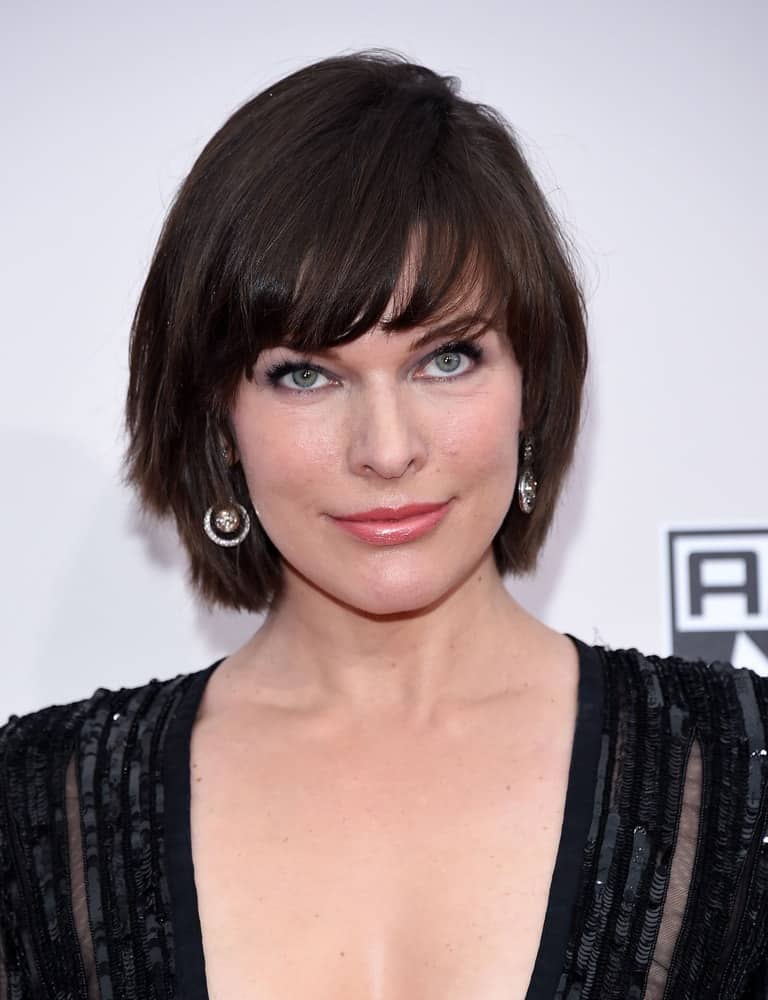Milla Jovovich attended the American Music Awards 2016 on November 20, 2016, in Hollywood, CA. She paired her black dress with a chin-length hairstyle that has dark bangs and layers.