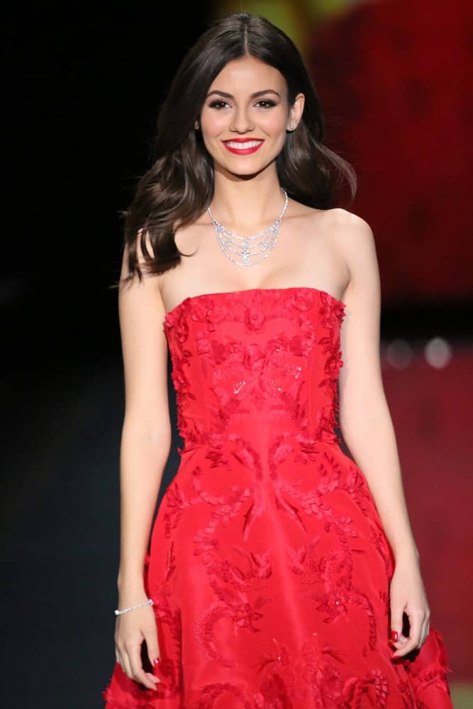 Victoria Justice, wearing Oscar de la Renta, walked the runway at Go Red For Women - The Heart Truth Red Dress Collection 2014 Show on February 6, 2014 in New York City. Her strapless red dress paired well with her long and wavy tousled hairstyle with layers.