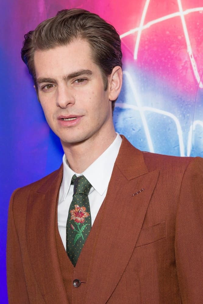 Andrew Garfield is undeniably handsome with a comb over look at the revival of Angels in America play after party last March 25, 2018. It was completed with a brown suit that's paired with a lovely floral print tie.