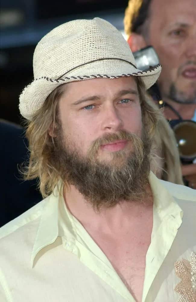 Brad Pitt wore a white fedora on top of his long and layered hair and massively unkempt bearded face back in 2002. He paired this with a casual white button down shirt.