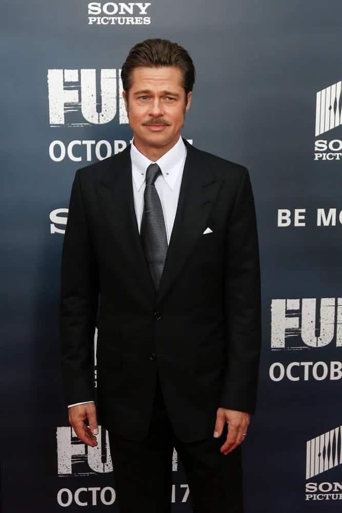 Brad Pitt brushed his hair back for a pompadour style to pair with his mustache at the world premiere of "Fury" at the Newseum last October 15, 2014 in Washington DC.