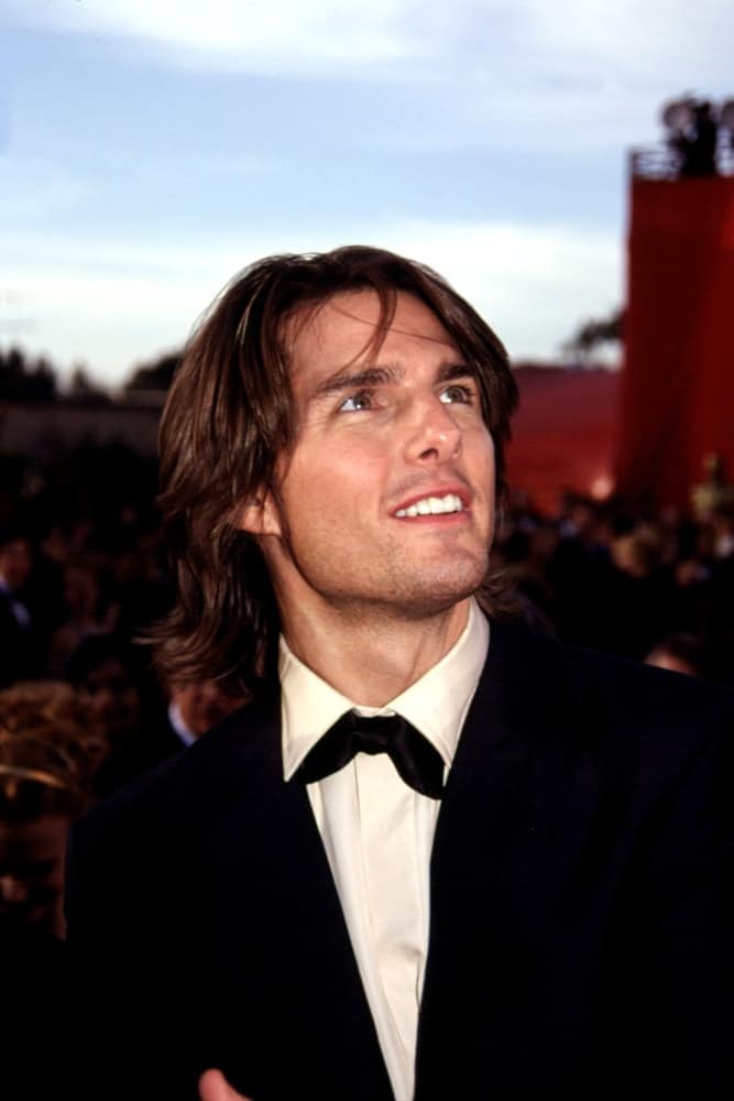 Tom Cruise wore a long and layered hairstyle that is parted in the middle paired with five o'clock shadow when he attended the Academy Awards back in 2000.