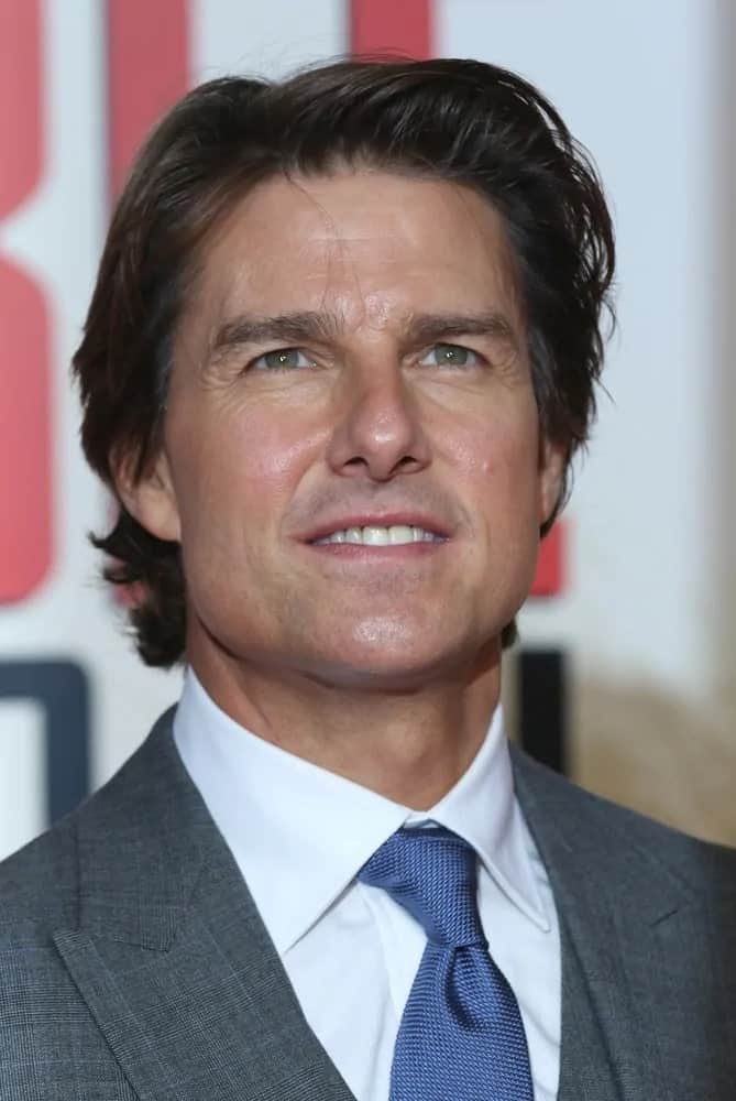 Tom Cruise wore a gray suit to pair with his long and shaggy hairstyle during the Mission Impossible: Rogue Nation - UK special screening at the BFI IMAX on Jul 25, 2015 in London.