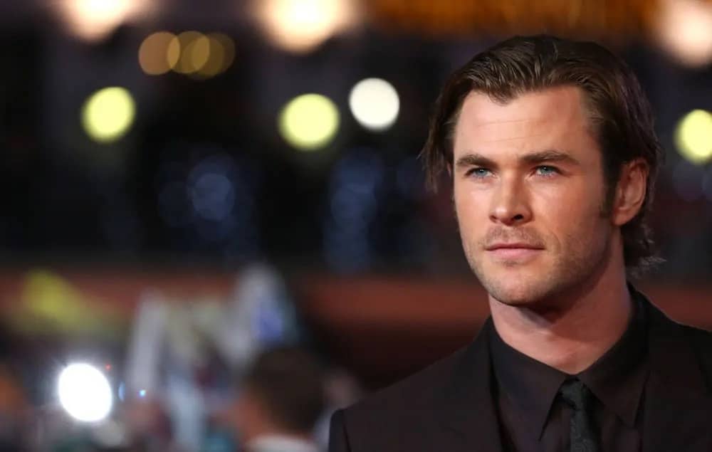 Chris Hemsworth had a mid-length slick side-swept hairstyle paired with a charcoal black suit during the world premiere of Thor The Dark World in London, 2013.