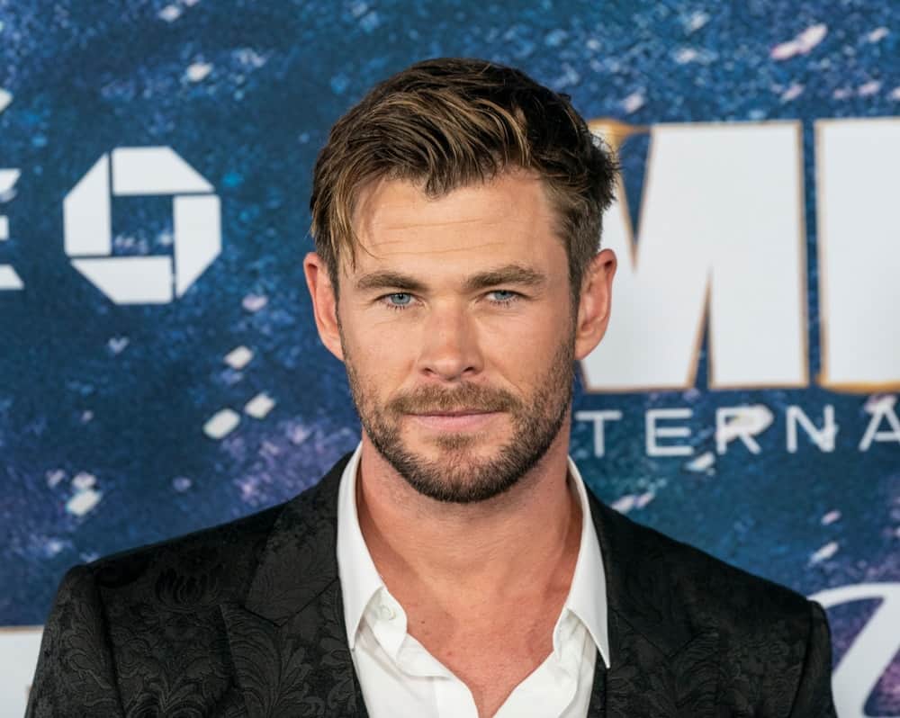 Last June 11, 2019, Chris Hemsworth wore a Dolce & Gabbana detailed black suit at the Men in Black: International premiere. He paired this with a highlighted tousled side-swept fade hairstyle capped off with a trimmed beard.