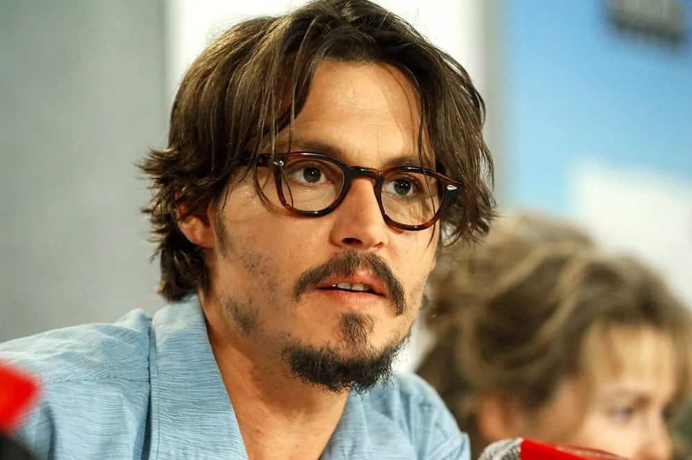 Johnny Depp appeared with a medium-length tousled hairstyle with a pair of glasses at the press conference for "Corpse Bride" during the Toronto Film Festival in 2005.