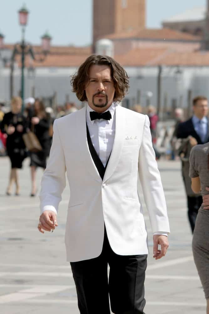 Actor Johnny Depp wore a slick white suit with his thick and long wavy hair with highlights during the film renewals  of "The Tourist " in San Marco square last May 13, 2010 in Venice, Italy.
