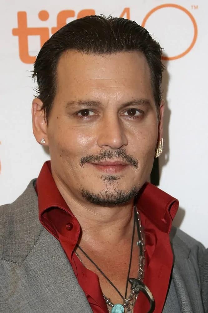 Actor Johnny Depp had his usually messy hair slicked back into this raven masterpiece paired with mismatched earrings and some necklaces during the "Black Mass" premiere at the 2015 Toronto International Film Festival last September 14, 2015 in Toronto, Canada.
