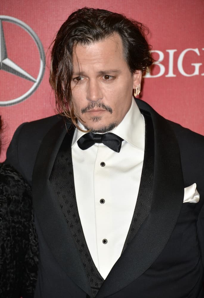 Last January 2, 2016, Actor Johnny Depp was at the 2016 Palm Springs International Film Festival Awards Gala. He wore a detailed black suit with bow that somehow compensates for his tousled and loose side-parted hair with highlights.