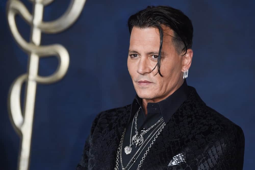 Last November 13, 2018, Johnny Depp was at the premiere for Fantastic Beasts: The Crimes of Grindelwald at Leicester Square. He showed up with a pitch black detailed suit and a long undercut hairstyle.